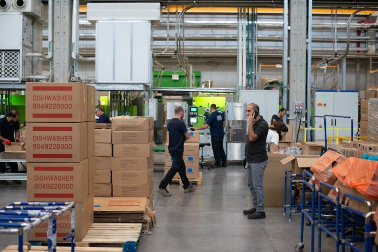 Packing area with cartons stacked on pallets and staff working the line